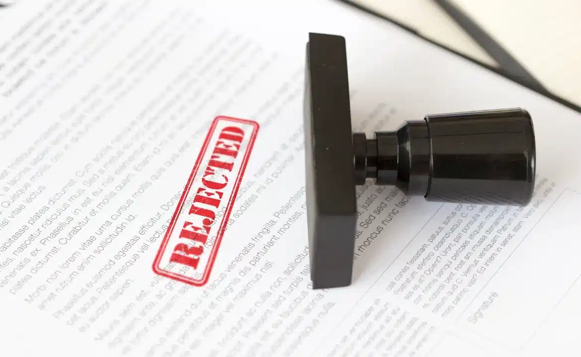 A close-up of a document featuring a prominent "Rejected" stamp, illustrating denial management automation.